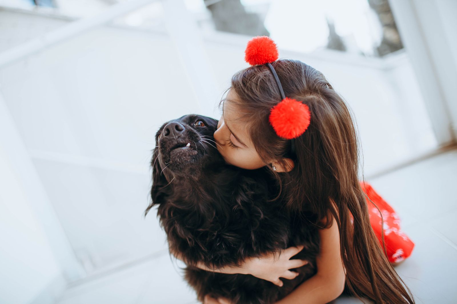 Une enfant embrasse son chien avec tendresse